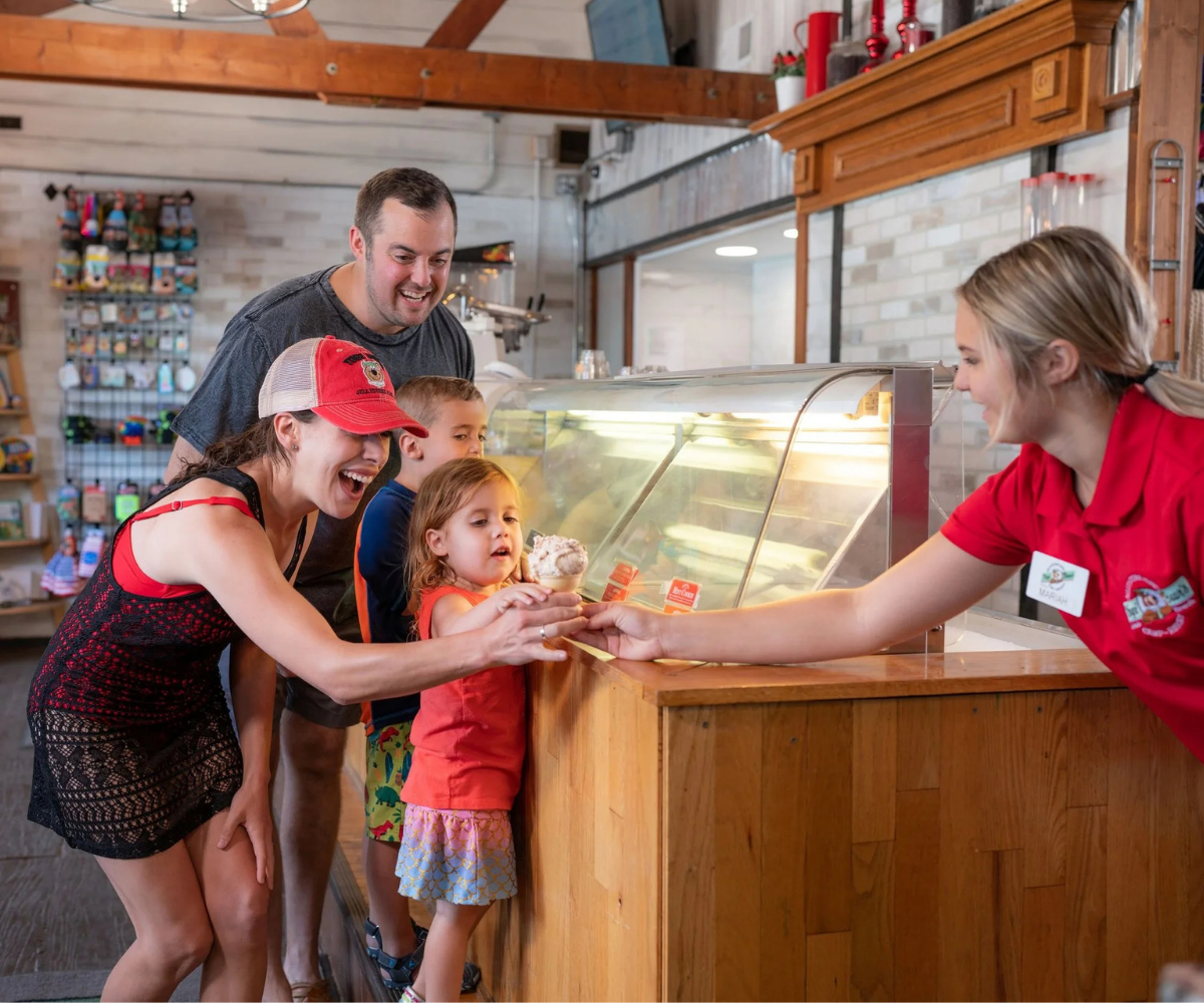 Family of campers enjoying Cedar Crest ice cream from the The Ranger Station™ at Jellystone Park™ Caledonia