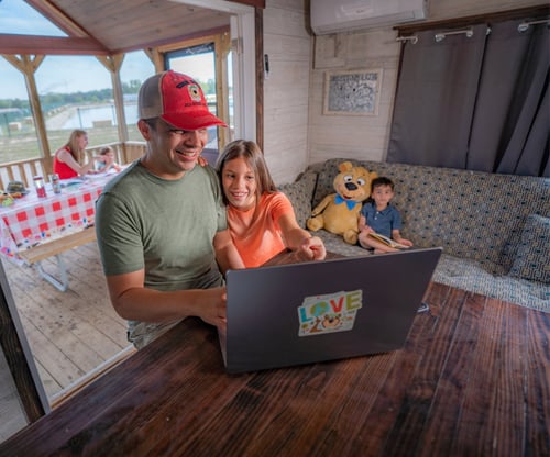 A family at Jellystone Park™ Caledonia using the complimentary WiFi available at the campground.