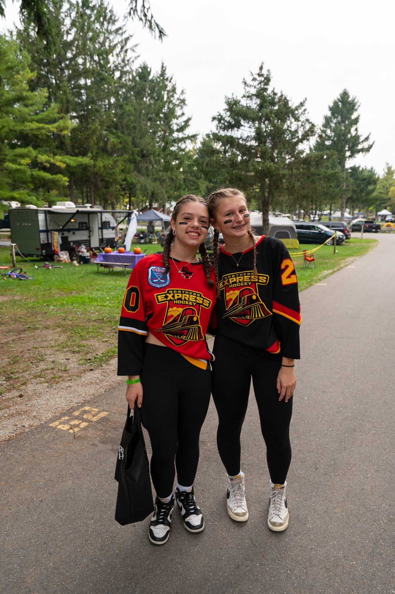 Two teenage girls dressed as hockey players smile for the camera during trick-or-treat at Jellystone Park™ Caledonia.