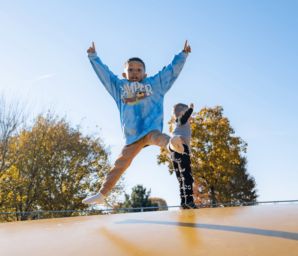 Young boy bouncing on a jumping pillow at Jellystone Park™ Caledonia during the late summer.