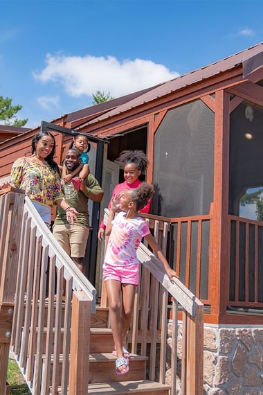 An image of a family walking down the stairs of a glamping cabin at Jellystone Park™ Caledonia.