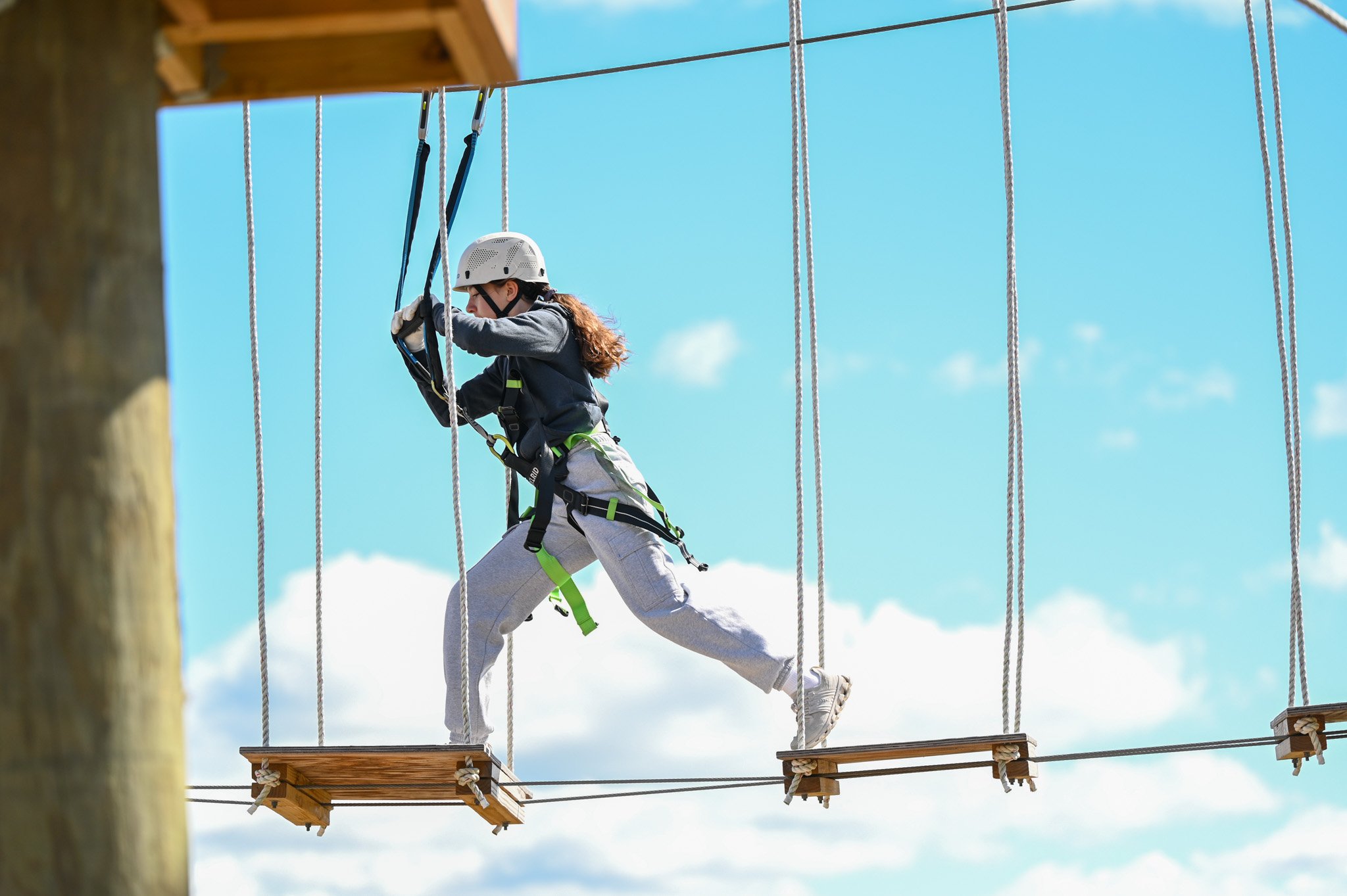 An image of a Jellystone camper on the ropes course. 