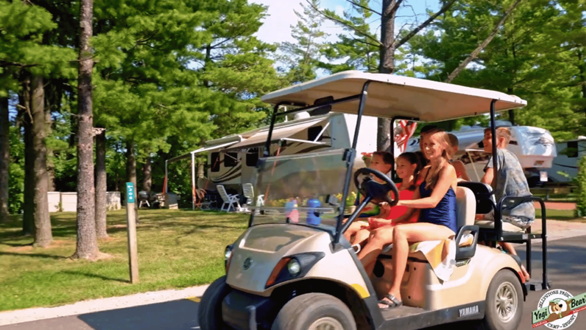 An image from Jellystone Park Caledonia of a family driving and having fun in a golf cart.