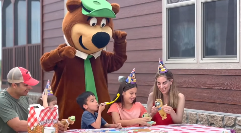 An image of a family camping at Jellystone Park with Yogi Bear.