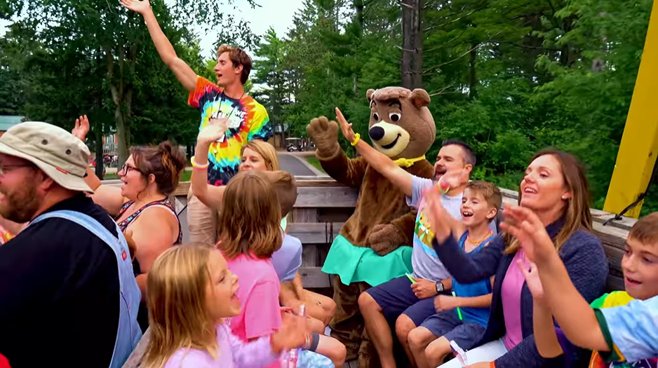 An image from Jellystone Park - Caledonia featuring a family and team members with Cindy Bear on a Hey! Ride. An image from Jellystone Park - Caledonia featuring a family and team members with Cindy Bear on a Hey! Ride.