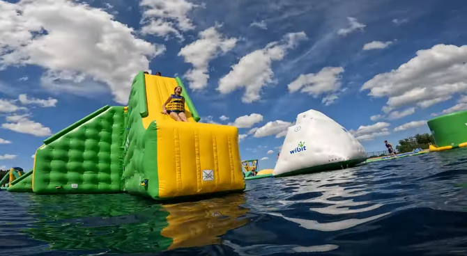 An image of a Jellystone camper sliding down a slide on Adventure Island.