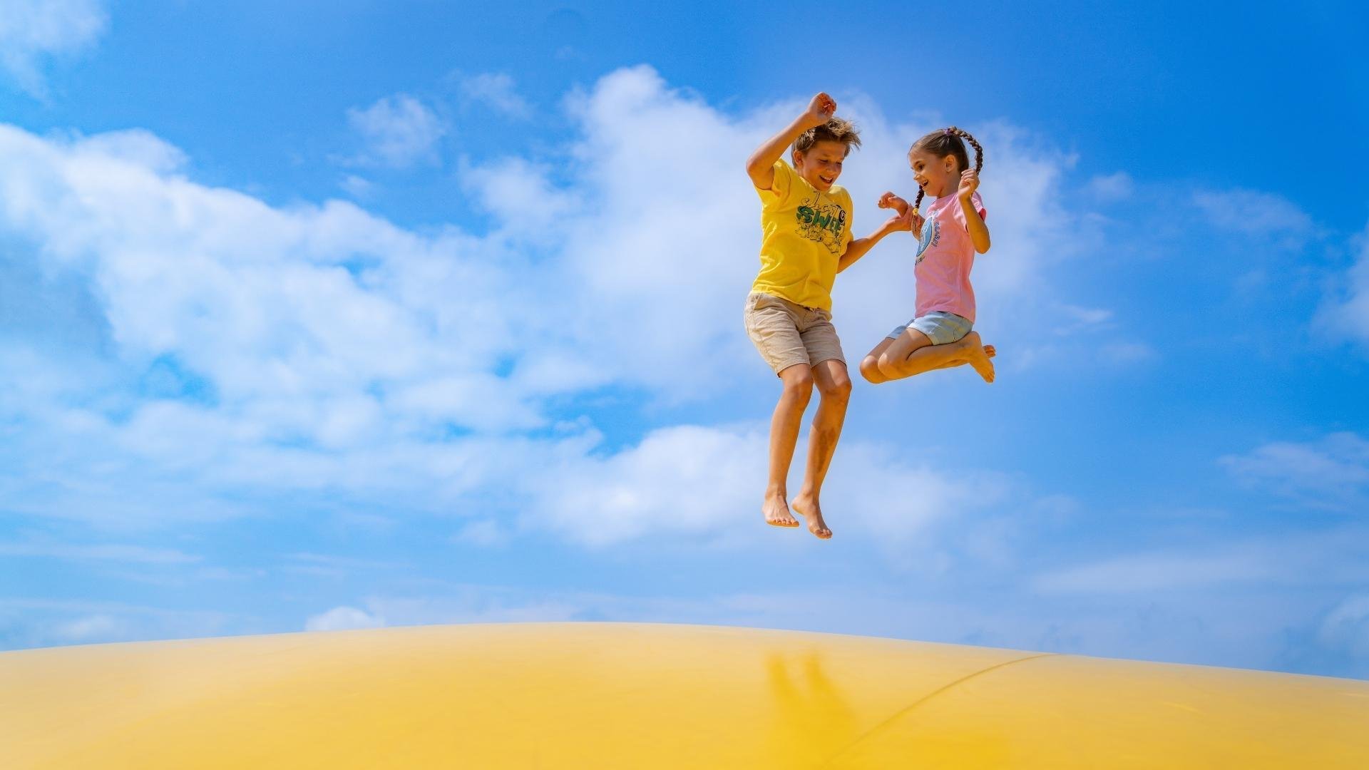 An image of two Jellystone campers on a jumping pillow.