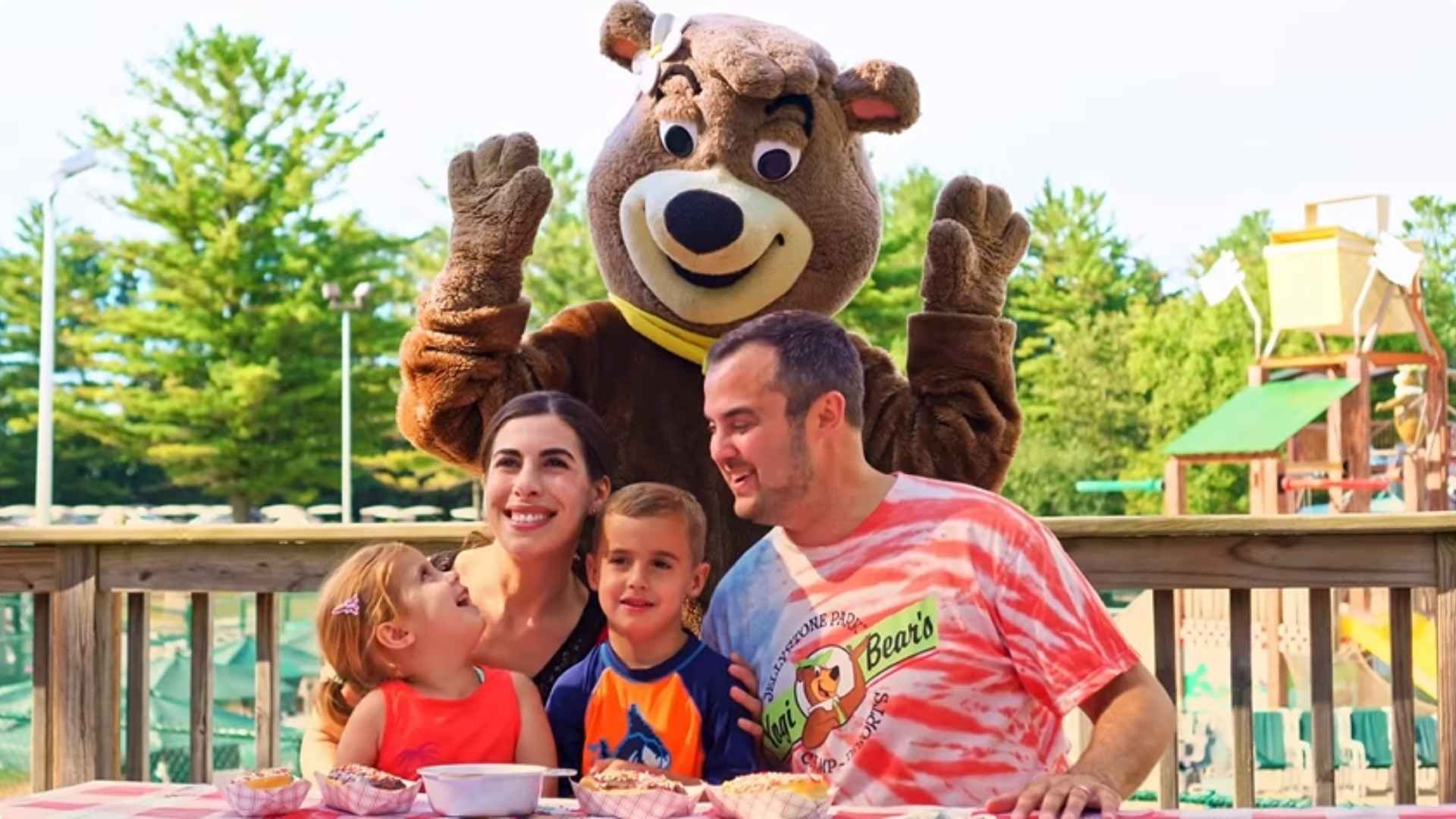An image of a family at Jellystone Park having fun with Cindy Bear.