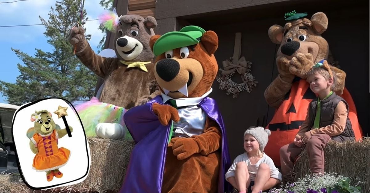 An image of two Jellystone Park campers posing with all three of the Bears on hay bales.