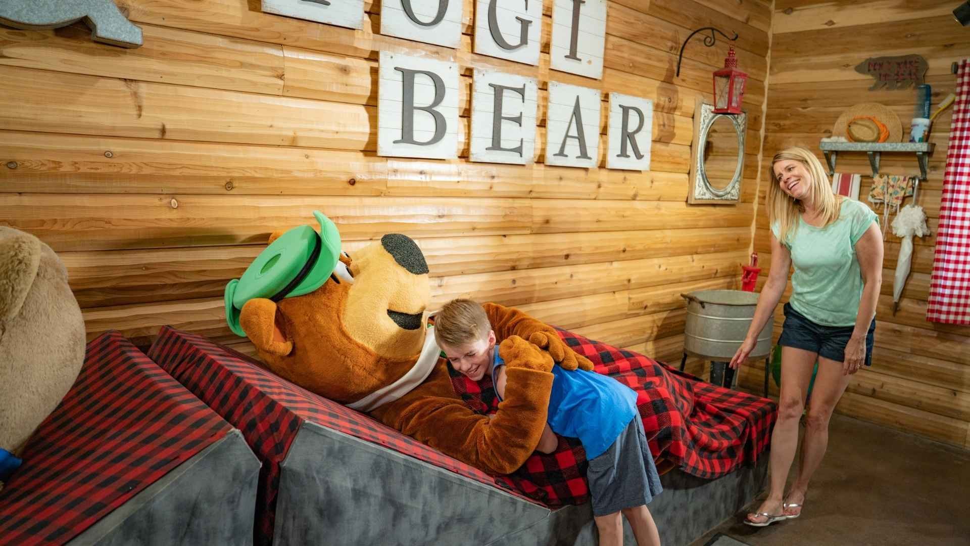 An image of a family tucking in Yogi Bear for the night.