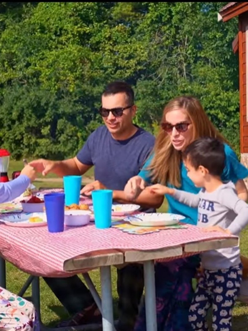 An image of a family eating breakfast outside their cabin at Jellystone Park™ Caledonia.